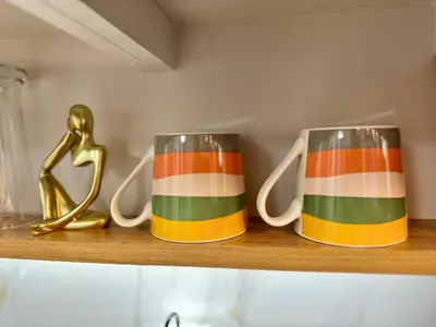 two striped coffee mugs sitting on a shelf at 1230 Flor Suite Shore 3 Residences near SM MOA by PrimeStay in Manila