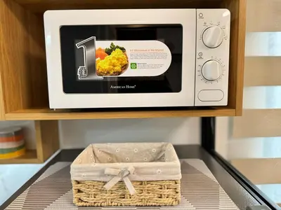 a microwave on a shelf with a box of food at 1230 Flor Suite Shore 3 Residences near SM MOA by PrimeStay in Manila