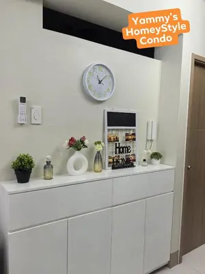 a white cabinet with a clock on a wall at Yammy's HomeyStyle Condo at Tower 3 Shore 3 Residences in Manila