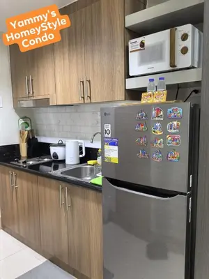 a kitchen with a refrigerator with magnets on it at Yammy's HomeyStyle Condo at Tower 3 Shore 3 Residences in Manila