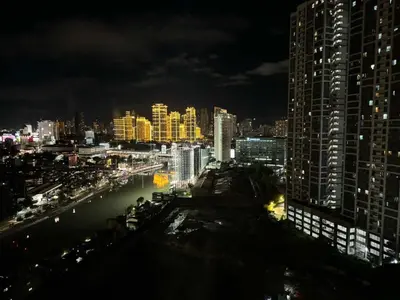 a city skyline at night with a river and buildings at Eve's Den in Manila
