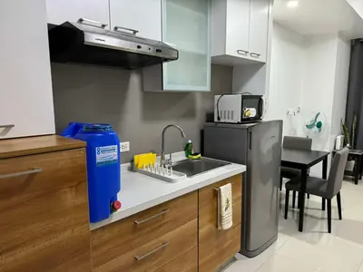 a kitchen with a sink and a refrigerator at Eve's Den in Manila