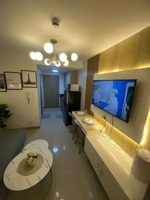 a living room with a large flat screen tv on the wall at Staycation At Shore 2 Residences Tower 2 in Manila