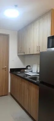 a kitchen with wooden cabinets and a black counter top at Staycation At Shore 2 Residences Tower 2 in Manila