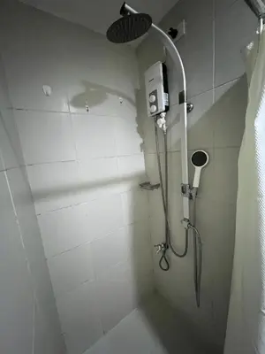 a bathroom with a shower with a shower head at Luxury in the Makati Skyline in Manila
