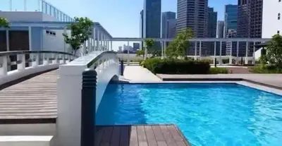a swimming pool with a city skyline in the background at Luxury in the Makati Skyline in Manila