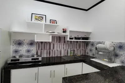 a kitchen with white cabinets and black counter tops at Jewelry Resort and Villas Tagaytay in Silang