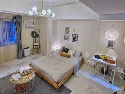 a bedroom with a bed and a desk in it at The Cozy Hub Studio with Wifi Near Eastwood City in Manila