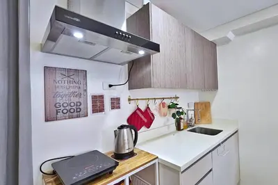a small kitchen with a sink and a stove at The Cozy Hub Studio with Wifi Near Eastwood City in Manila