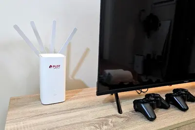 a white vase with white sticks in it next to a tv at The Cozy Hub Studio with Wifi Near Eastwood City in Manila