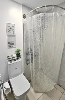 a white shower curtain in a bathroom with a toilet at The Cozy Hub Studio with Wifi Near Eastwood City in Manila