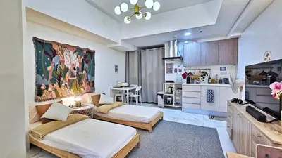 a room with two beds and a kitchen at The Cozy Hub Studio with Wifi Near Eastwood City in Manila