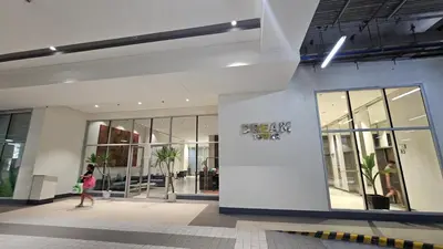 a woman walking in front of a building at The Cozy Hub Studio with Wifi Near Eastwood City in Manila