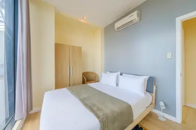a bedroom with a white bed and a window at StayHere 3BR Penthouse Knightsbridge Makati in Manila