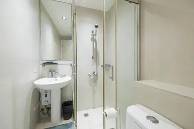 a white bathroom with a sink and a shower at StayHere 3BR Penthouse Knightsbridge Makati in Manila