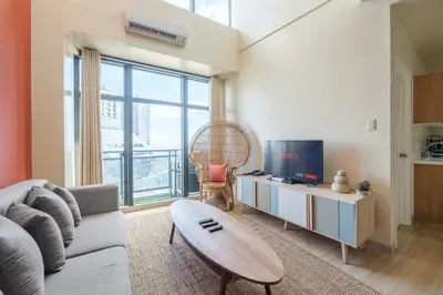 a living room with a couch and a table at StayHere 3BR Penthouse Knightsbridge Makati in Manila