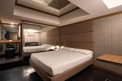 a bedroom with two beds and a bathroom at Victoria Court Hillcrest in Manila