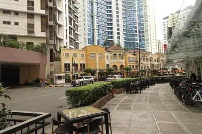 a city street with tables and chairs and buildings at Luxury Condo at Forbeswood Parklane The Fort BGC in Manila