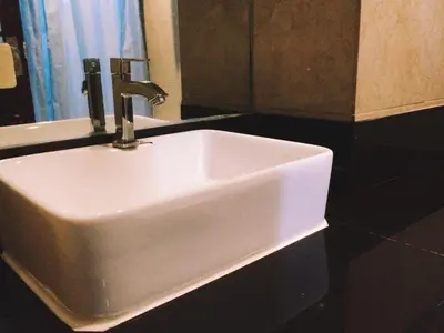 a white sink in a bathroom with a mirror at Chinatown Lai Lai Hotel Inc in Manila
