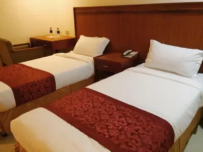 a hotel room with two beds with white and red sheets at Chinatown Lai Lai Hotel Inc in Manila