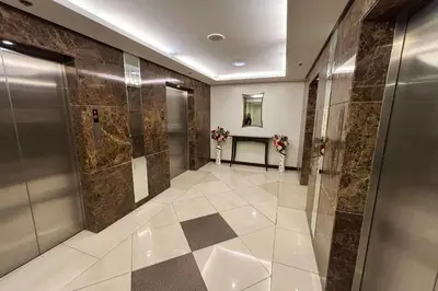 a bathroom with a walk in shower and a tile floor at Extremeli Suites in Manila