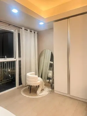 a room with a white chair and a mirror at Exquisite Japandi at Venice with Grand Canal view in Manila