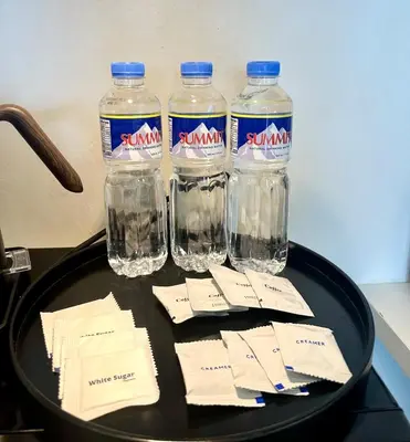 four bottles of water sitting on a table with envelopes at Exquisite Japandi at Venice with Grand Canal view in Manila