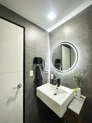 a bathroom with a white sink and a mirror at Exquisite Japandi at Venice with Grand Canal view in Manila