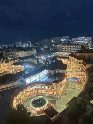 a large building with a courtyard in a city at night at Exquisite Japandi at Venice with Grand Canal view in Manila