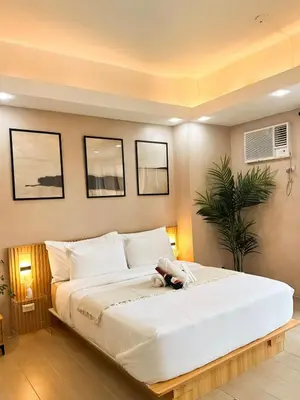a large white bed with a stuffed animal on it at Exquisite Japandi at Venice with Grand Canal view in Manila