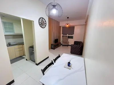 a kitchen and a dining room with a table and chairs at Wanderlust Haven in Manila