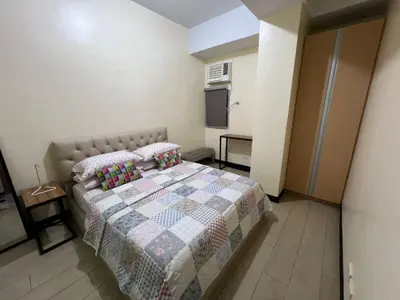 a bedroom with a bed with a quilt on it at Wanderlust Haven in Manila