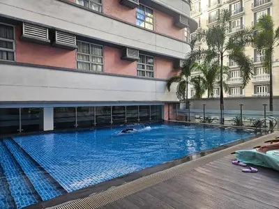 a swimming pool in front of a building at Wanderlust Haven in Manila