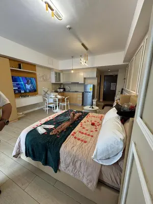 a bedroom with a large bed and a kitchen at Venice Staycation Cozy Glimpse of Grand Canal View Retreat in Manila