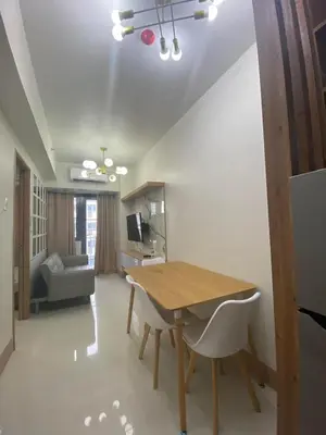 a dining room with a table and a couch at Happy Haven At Shore 3 Moa Pasay in Manila