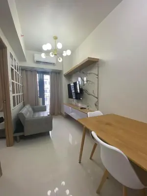 a living room with a table and a couch at Happy Haven At Shore 3 Moa Pasay in Manila