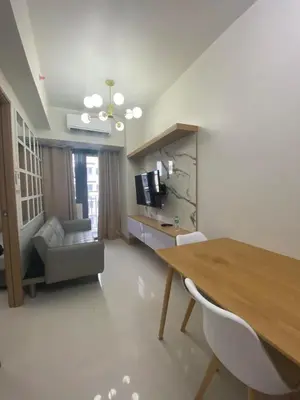 a living room with a table and a couch at Happy Haven At Shore 3 Moa Pasay in Manila