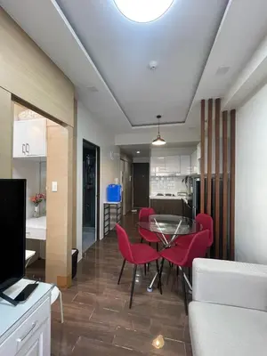 a living room with a table and red chairs at Beauty Makati Penthouse 4 room Family Condo in Manila