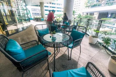a patio with tables and chairs and people on a balcony at Beauty Makati Penthouse 4 room Family Condo in Manila