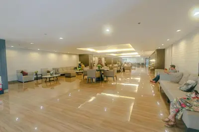 a lobby with people sitting on couches and tables at Beauty Makati Penthouse 4 room Family Condo in Manila