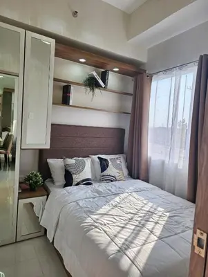 a bedroom with a large bed and a window at Stunning 2 Bedroom near Airport in Manila