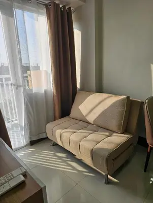 a couch sitting in a room with a window at Stunning 2 Bedroom near Airport in Manila
