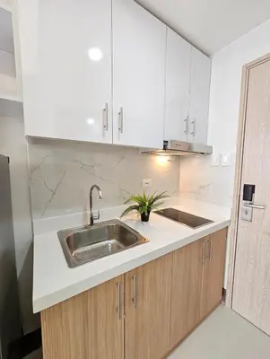 a kitchen with white cabinets and a sink at Stunning 2 Bedroom near Airport in Manila
