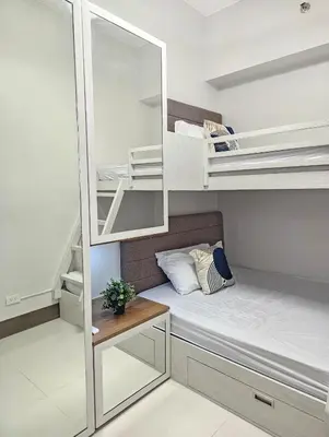 a small room with bunk beds and a mirror at Stunning 2 Bedroom near Airport in Manila