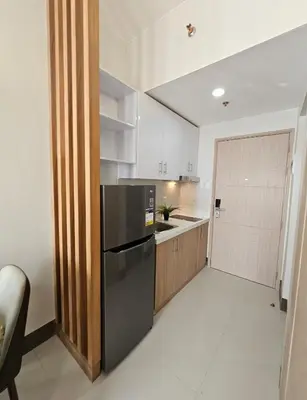 a kitchen with a black refrigerator in a room at Stunning 2 Bedroom near Airport in Manila