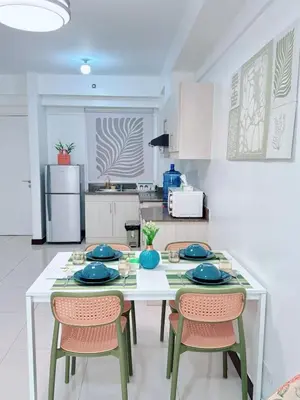 a kitchen with a table and chairs with blue dishes on it at Near NAIA 3 Condo in Manila