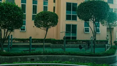 a park with trees in front of a building at Venice Stay! Free Amenities, Steps to Grand Canal in Manila