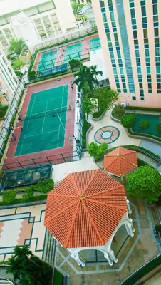 an overhead view of a tennis court with two orange umbrellas at Venice Stay! Free Amenities, Steps to Grand Canal in Manila