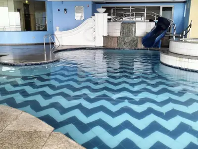 a pool with a water slide in a building at Chic Haven in Manila