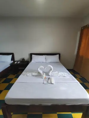 a bed with two heart shaped towels on it at Manalo Resort Hotel in Tutulo
